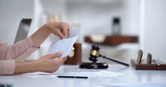 Divorced woman holding envelope with alimony
