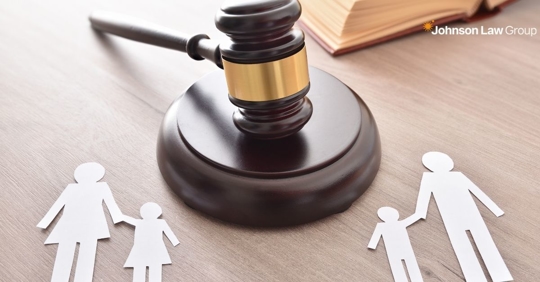 gavel on a desk with cutouts of a split family