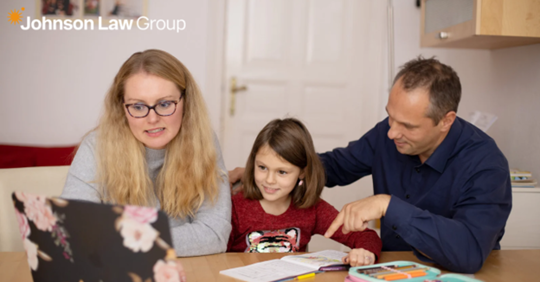 parents helping a young girl with a laptop