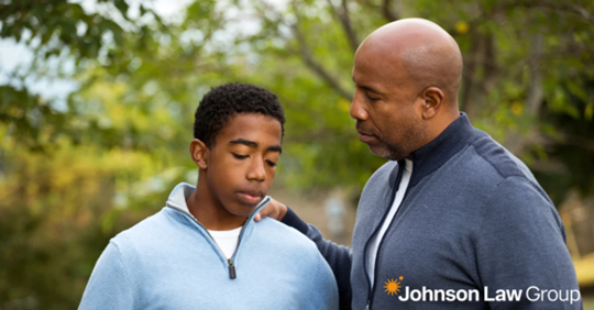 father with his hand on his son's shoulder