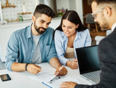 couple signing documents with a lawyer