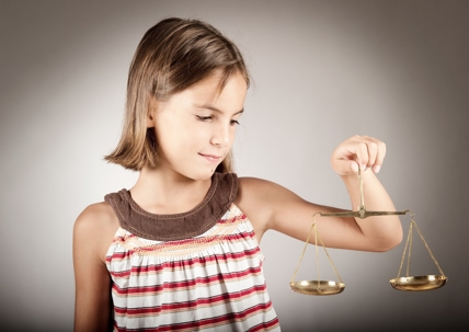A young girl holding scales