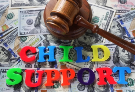 Child support in letters on top of cash bills
