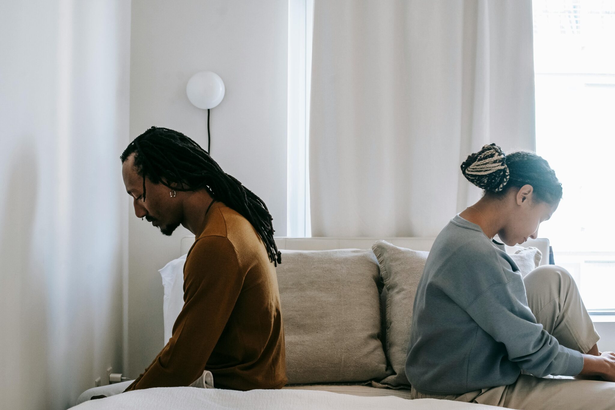 Couple sitting peacefully back-to-back with calm expressions, representing a cooperative and amicable uncontested divorce process.