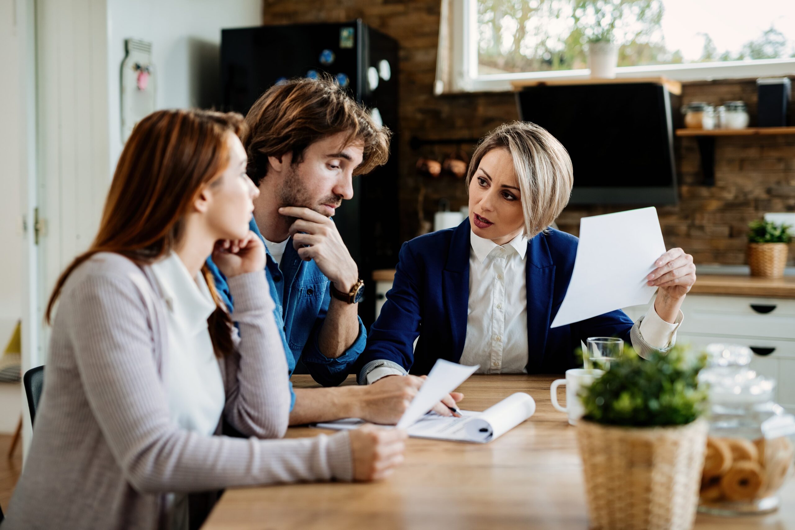 A couple sitting at a table talking with a lawyer, representing the details of what goes into a Colorado separation agreement and why a poorly drafted one can cost you later.