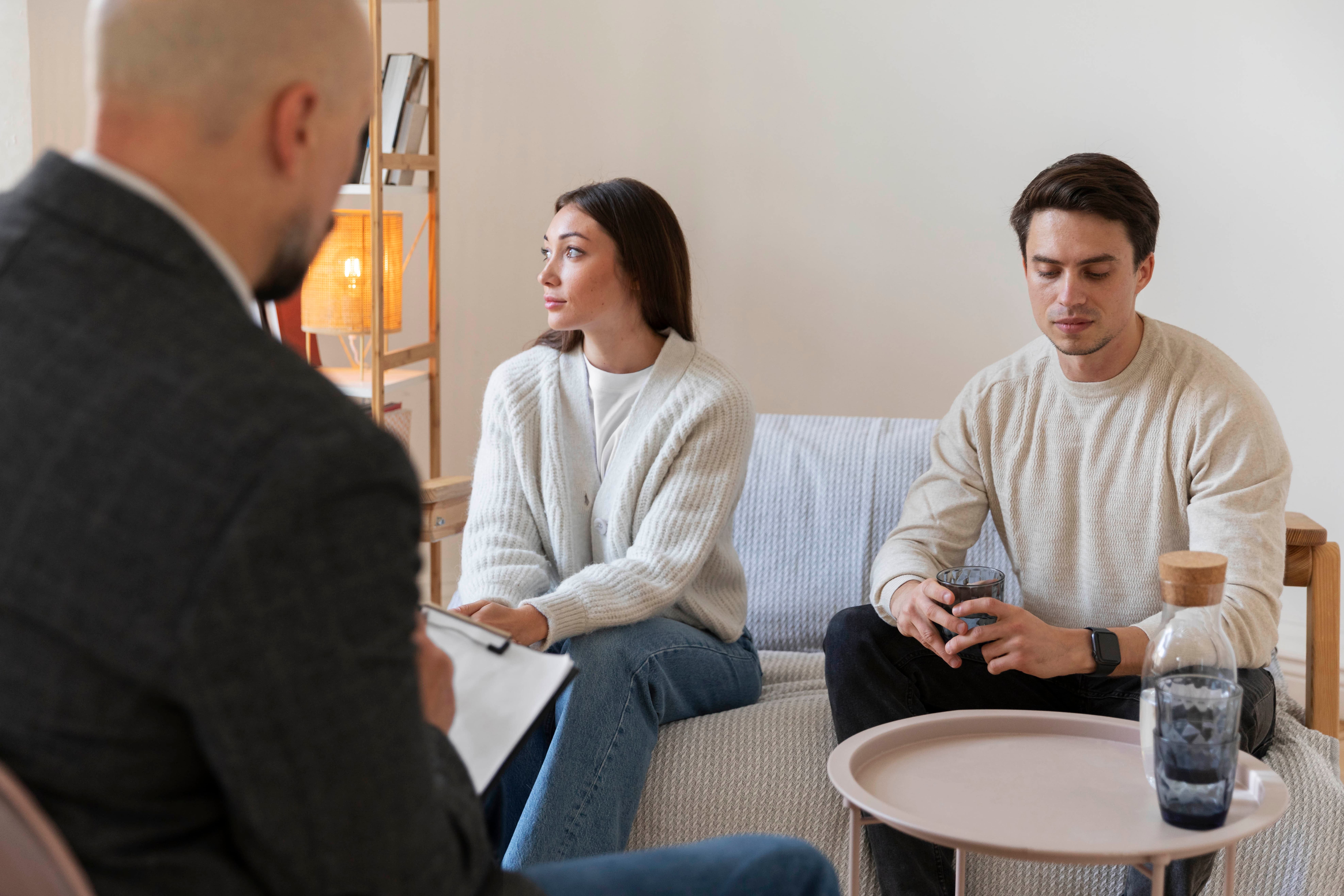 A couple sitting at a table talking with a lawyer, representing the process and preparation for how divorce mediation works in Colorado.